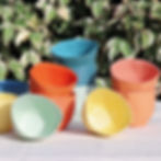 Group of bright coloured ceramic cups with no handles