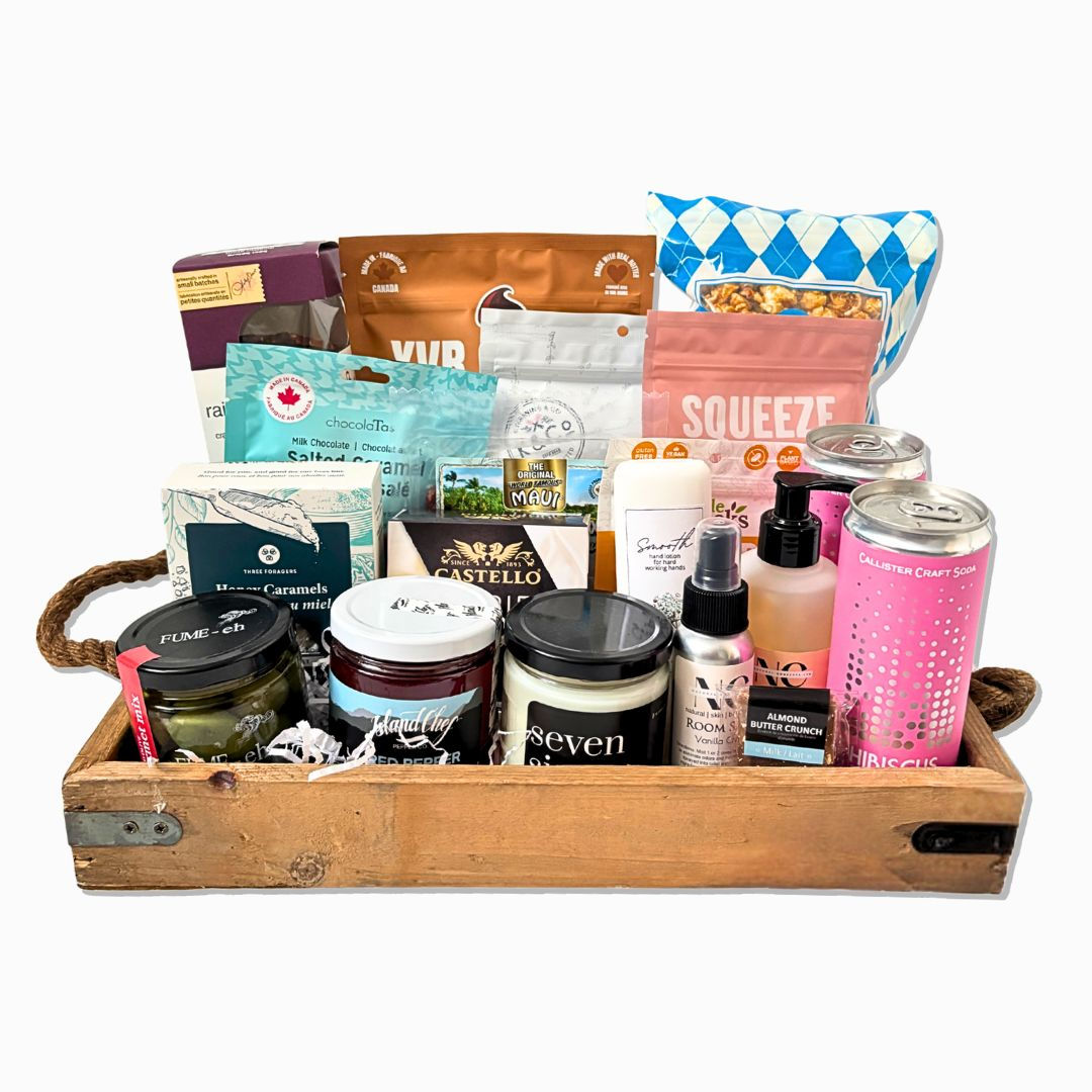 Gift basket with local British Columbia products, including cookies, hand soap, chocolate, soda and olives.