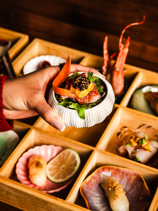 hand holding an omakase sushi portion