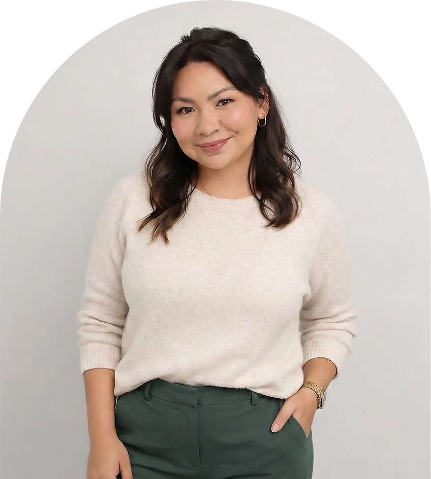 Anna Armendariz, smiling and wearing a light sweater and dark pants, looking at camera.