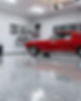 Red classic car in a clean garage with epoxy floor and bikes
