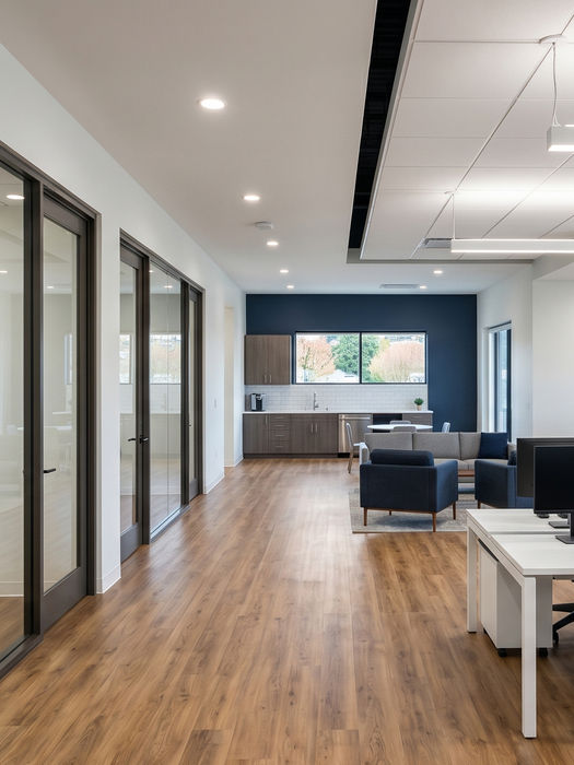 Modern open-plan office with glass conference rooms and desks.