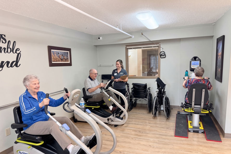 Older adults exercising with staff in a rehabilitation gym