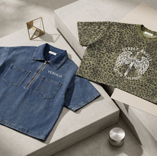 Blue zip-front denim shirt and olive leopard tee on white blocks, both branded YESHUA; streetwear flat lay with bold graphic text