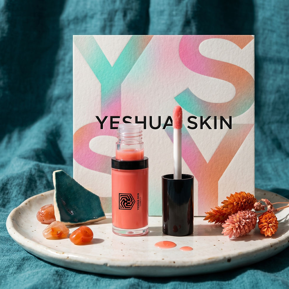 YESHUA SKIN cosmetic bottle and gloss wand on a tray with stones and dried flowers, pastel box behind, teal fabric backdrop.