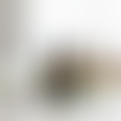 Two amber dropper bottles labeled "Glycolic Acid Serum" and "Hydration Serum" on a marble surface with leaves, orchid, and skincare tools.