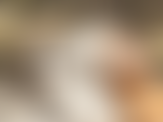 Woman relaxing with a facial mask in a spa setting. Exfoliate cream by Yeshua Skin on a table with white bowls and an orchid nearby.