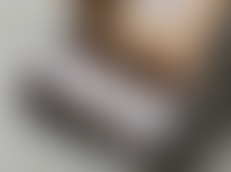 Open box with six brown bottles on shredded paper. Box has black and white geometric patterns and shipping label on a gray surface.