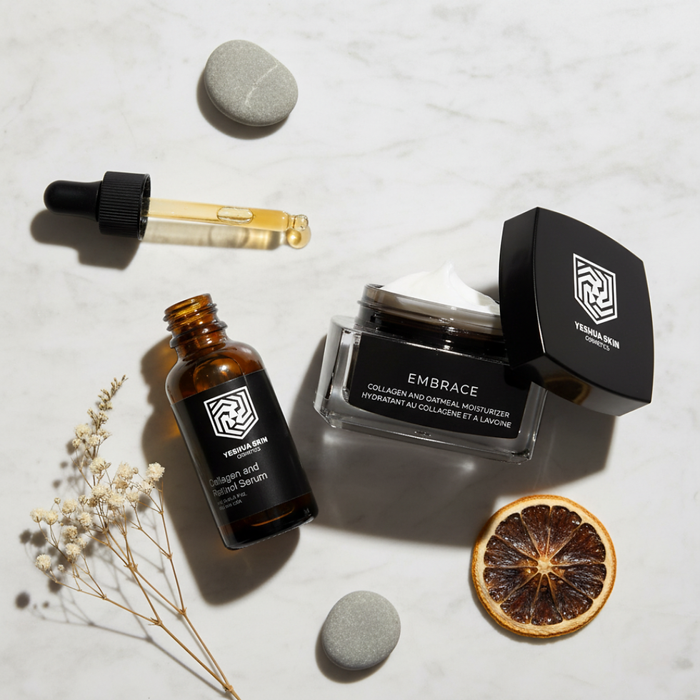 Skincare items on marble: a brown serum bottle, dropper with liquid, moisturizer jar, grey stones, dried citrus slice, and small flowers.