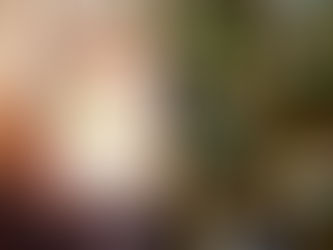 金色リボンを白い箱にかけたギフトを両手で持っている女性