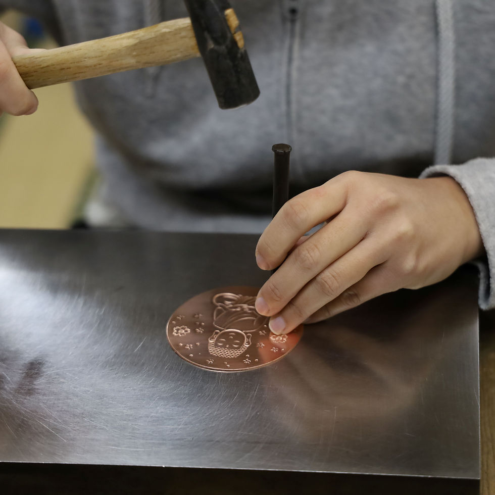 大仏の描かれた銅板に彫金している様子