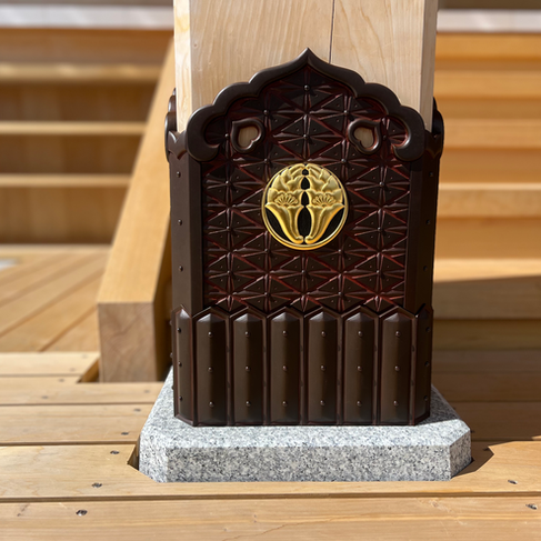 金色の月影杏葉紋がついた飴色の沓巻金具が、寺の柱の根もとに取り付けられている。