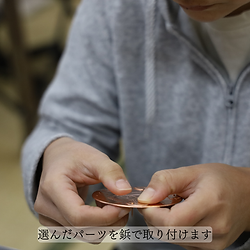 銅板にパーツを取り付けている