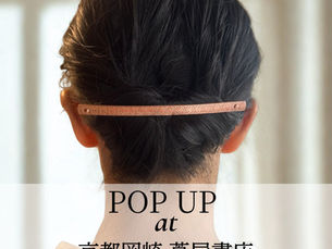 まとめ髪に銅製のロングバレッタをつけた女性の後ろ姿