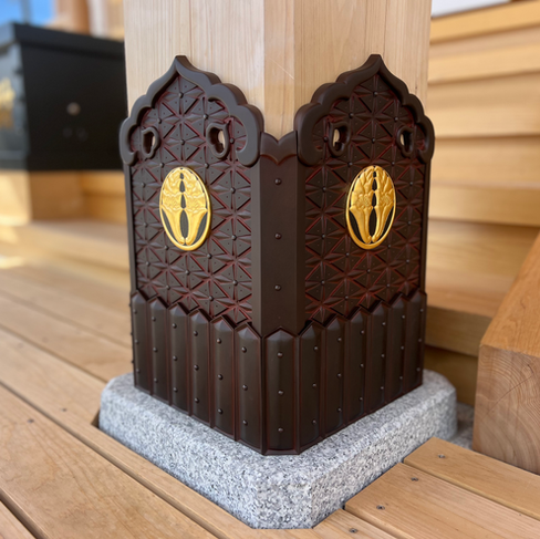 金色の月影杏葉紋がついた飴色の沓巻金具が、寺の柱の根もとに取り付けられている。