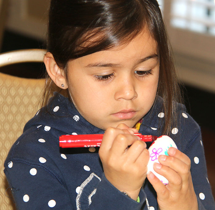 wLittle girl painting egg