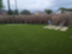 Residential turf lawn with putting green and seating.