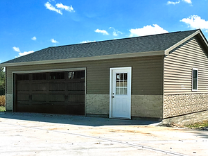 Finished product photo of a two car garage with beautiful siding and stone veneer