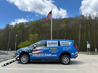 Blue van with Harlan CAA decal and American flag in the background