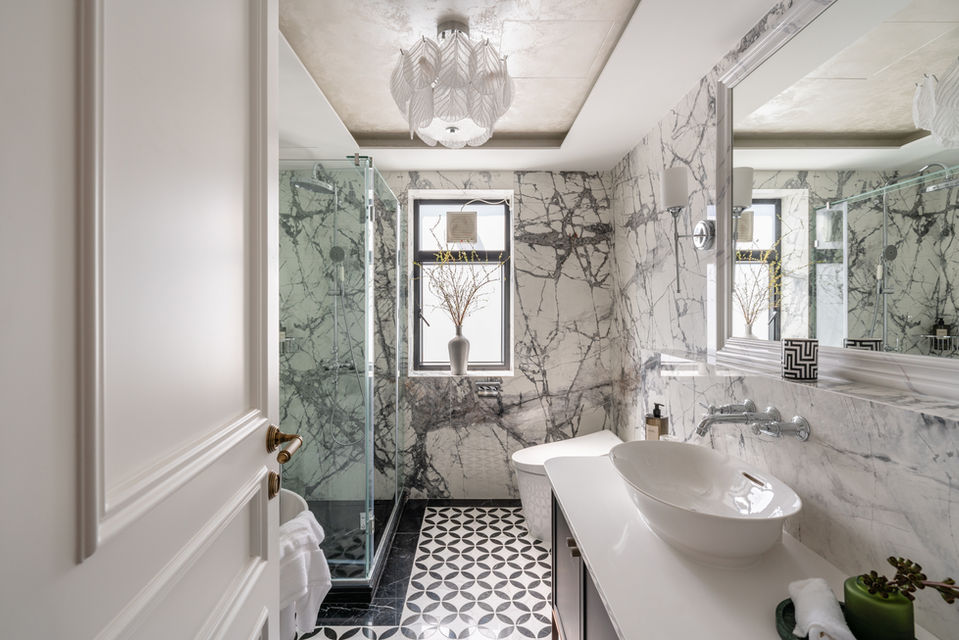 Luxurious marble bathroom design by MAD Studio, featuring elegant interior décor, modern fixtures, and a stylish glass shower. Ideal for upscale home renovations and sophisticated interior design projects.