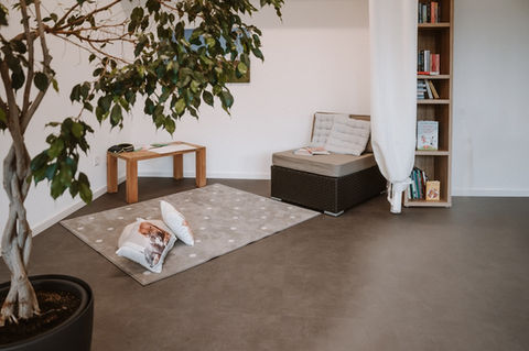Einladender und heller Praxisraum von Manuela Buesser mit einer gemütlichen Sitzecke für Kinder- und Familiencoachings.