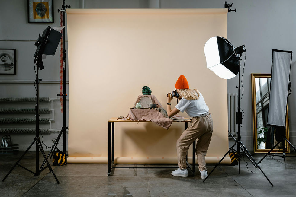 Photographe en studio en train de prendre une photo produit professionnelle avec lumière et décor.