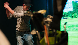 En mann spiller golf i Håkons hall