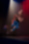 Deux danseuses vêtues de pantalons bleus et de chandails des années 70 font un saut synchronisé dans les airs