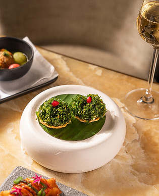 This image contains a photo of a dish named papdi chaat, crackling spinach from Indian Accent Mumbai