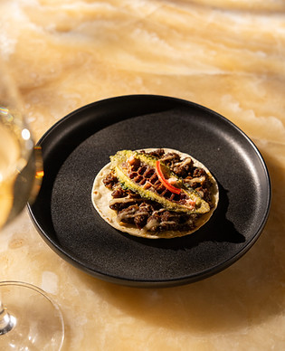 This image contains dish named meat ka karela, baked naan, kalonji seed fom Indian Accent Mumbai