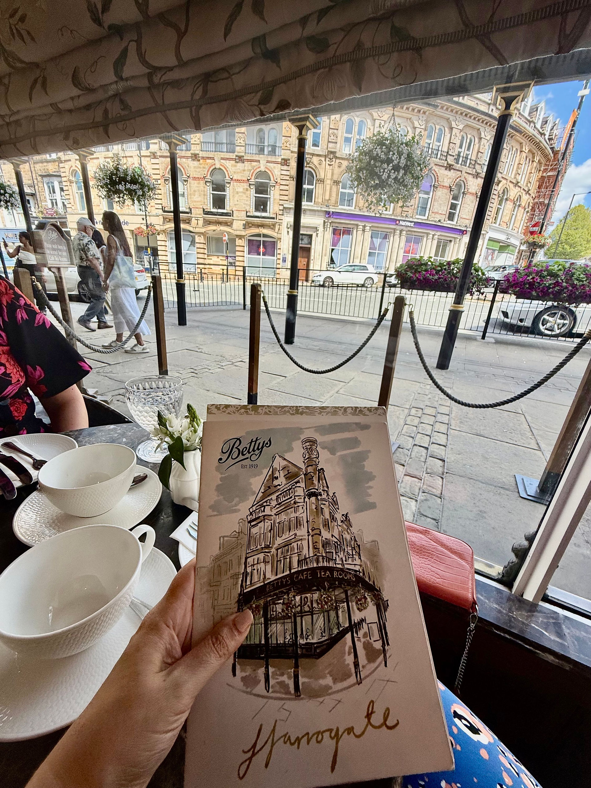 Hand holding a vintage brochure, view of buildings, Harrogate’s Best Places for Drinks with a View.