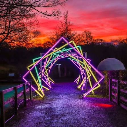 Neon-lit archway against a colorful sunset, Harrogate's best places to drink.