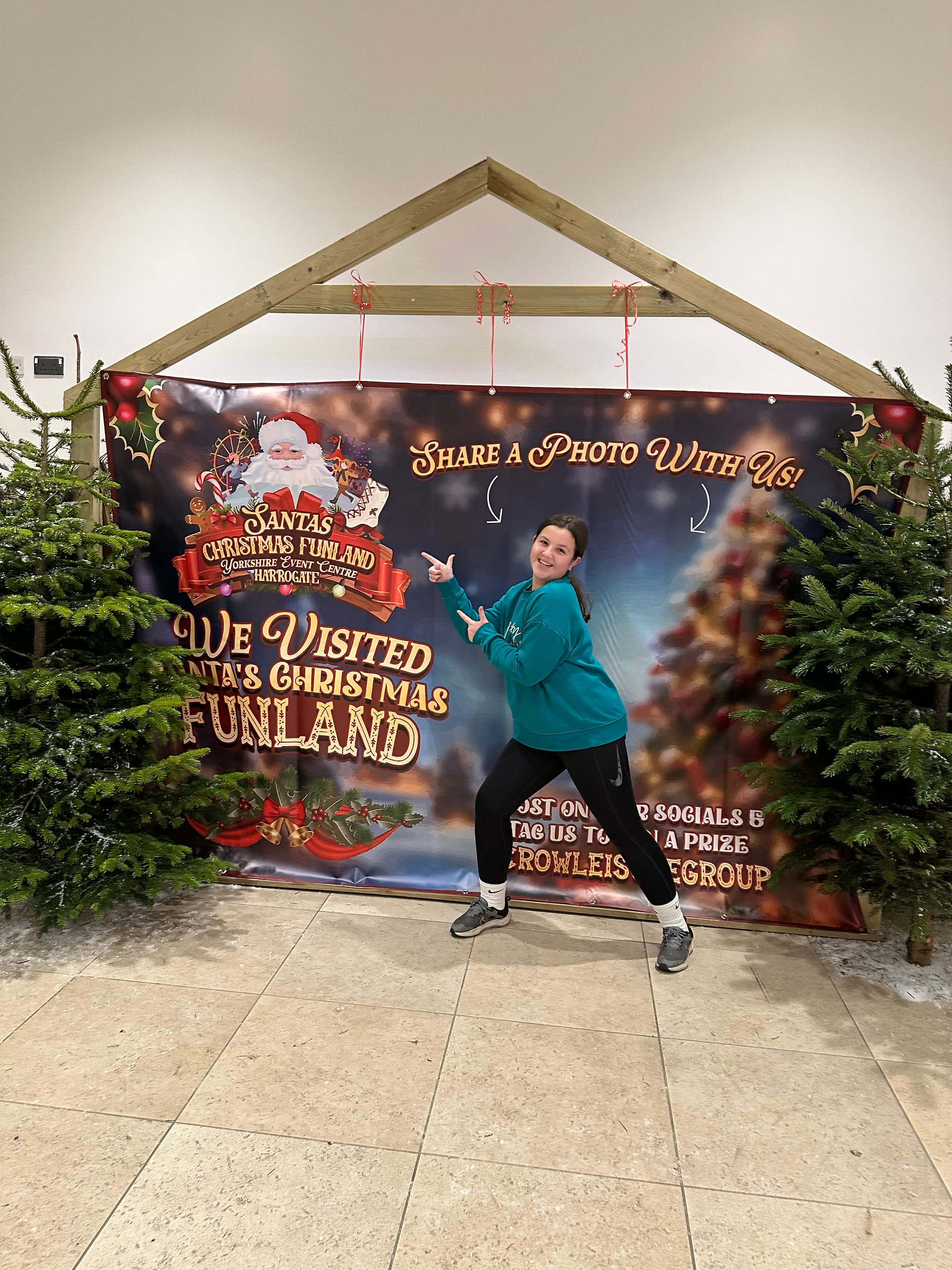Young woman pointing at Santa's Christmas Funland sign. Share a photo with us!