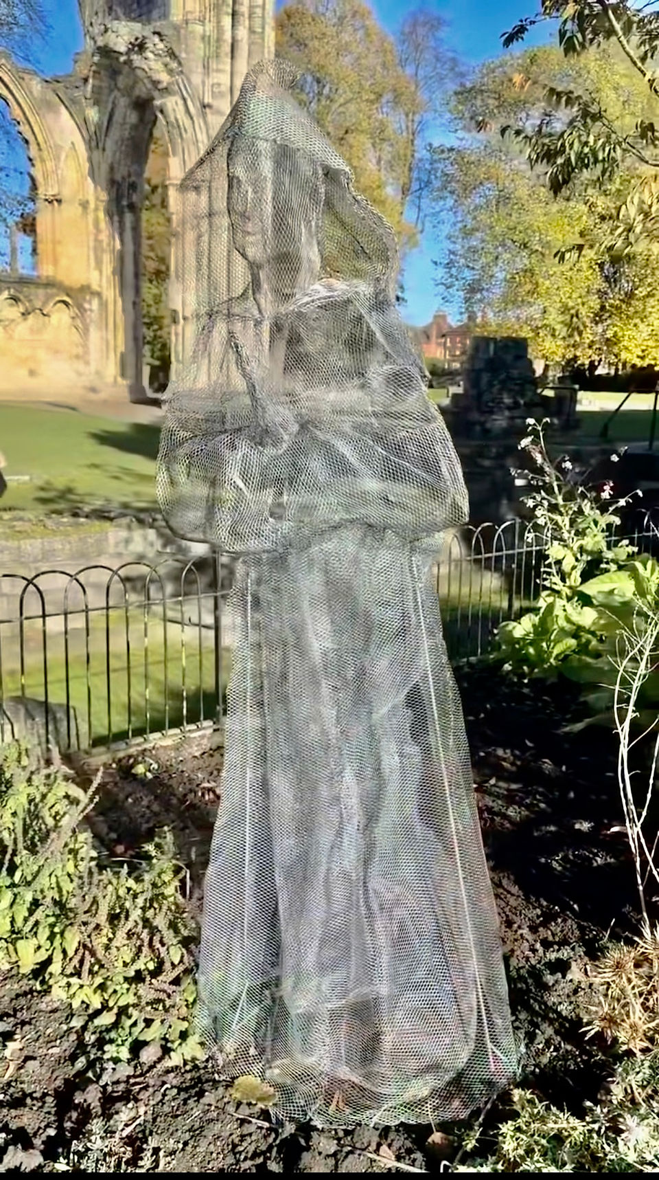 Ghosts in the garden figurine made from see through chicken wire so they are visible but also see through