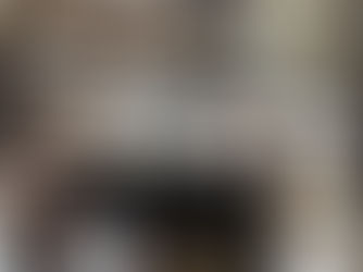 A messy desk with piles of books and papers.