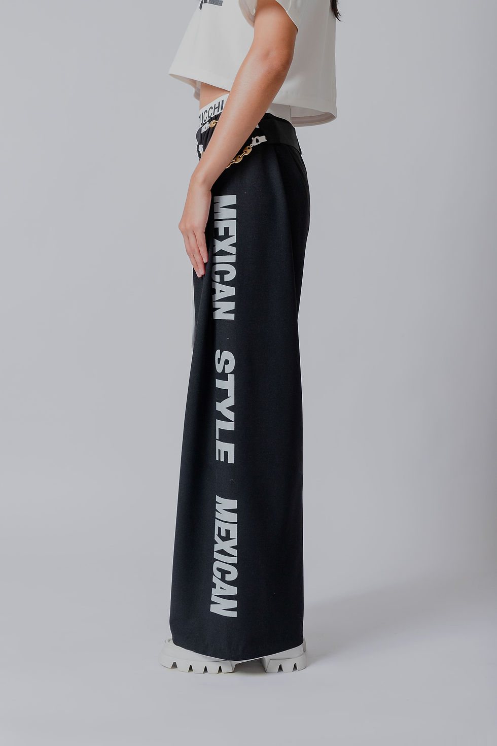 Miniatura: 白のゴムバンドに黒のストリート柄がプリントされた黒のワイドパンツ。サイドの片足にメキシカン・スタイルの文字。白のバッグに取り外し可能な黒。