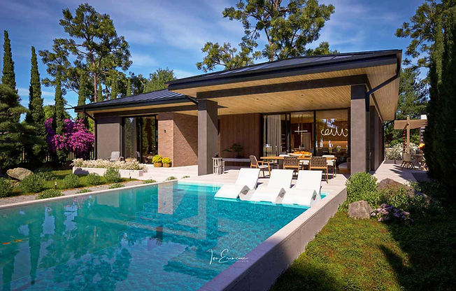 Front exterior view of a modern 3 bedroom single story house plan featuring a covered terrace, swimming pool and private garden