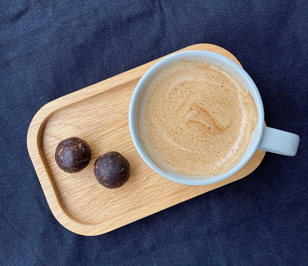 2 bliss balls on wooden tray with cup of coffee