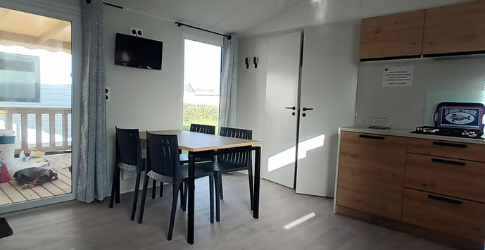 Vue du coin repas du mobil home locatif avec terrasse à vendre au Camping Les Flots Bleus à Piriac sur mer