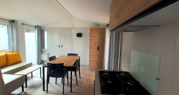 Vue du fond de la cuisine, sur la pièce à vivre du Mobil home Bahia au Camping Les Flots Bleus de Piriac-sur-Mer