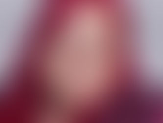 Head shot of Shaunia, with a warm smile and vivid hair