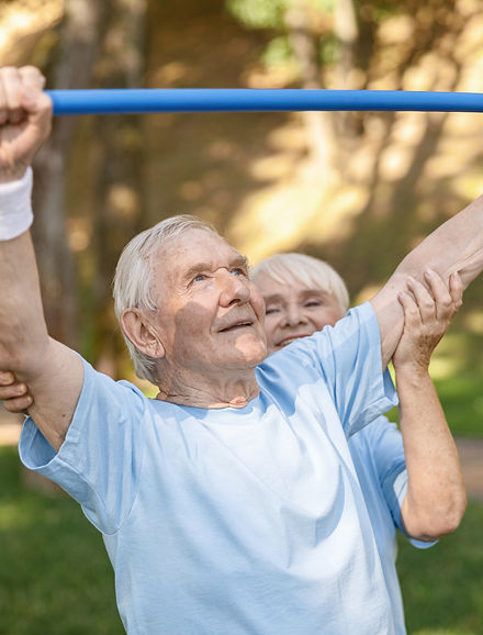 senior-woman-trainer-helps-man-exercise-with-bar-green-park.jpg