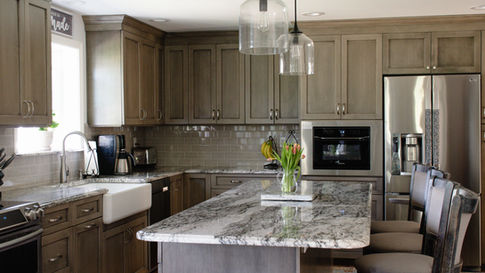 A kitchen with wooden cabinets, a farmhouse sink, and quartz countertops.