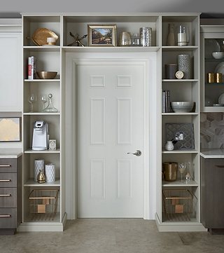 A custom built shelving system above a kitchen door.