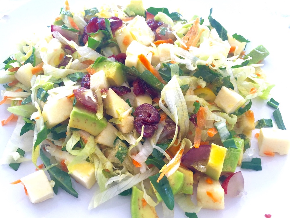 Varios tipos de ensalada con ensalada, fruta fresca, frutos secos aderezados con aceite de oliva virgen extra italiano