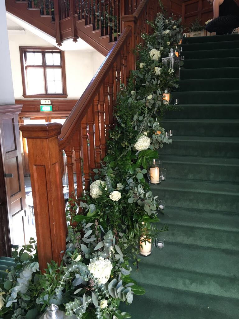 statement floral staircase arrangement white hydrangeas and eucalyptus