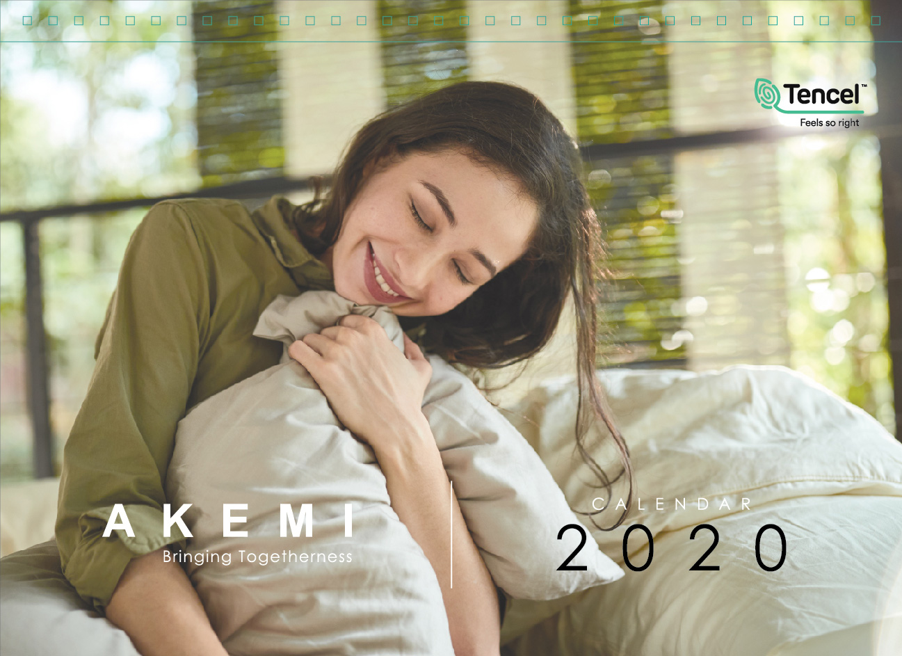 Akemi 2020 calendar with woman smiling on a bed hugging the blanket