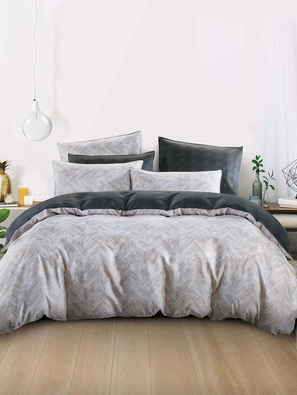 Hooga light grey and dark grey bed in a minimalistic room with a big hanging light bulb at the side