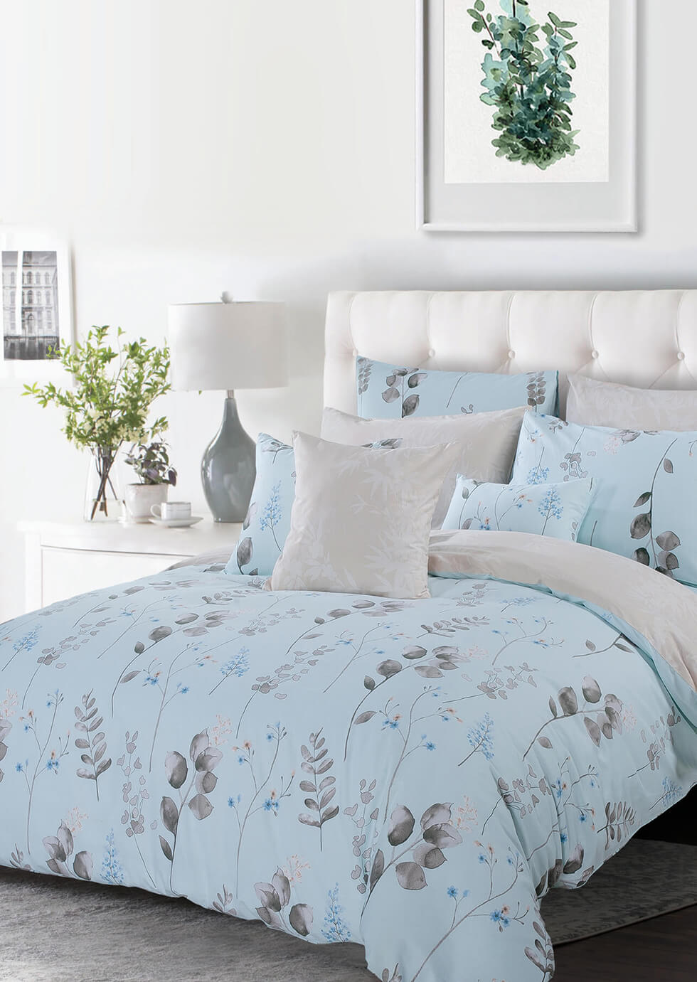 baby blue bed with grey floral pattern and a plant picture frame on the wall