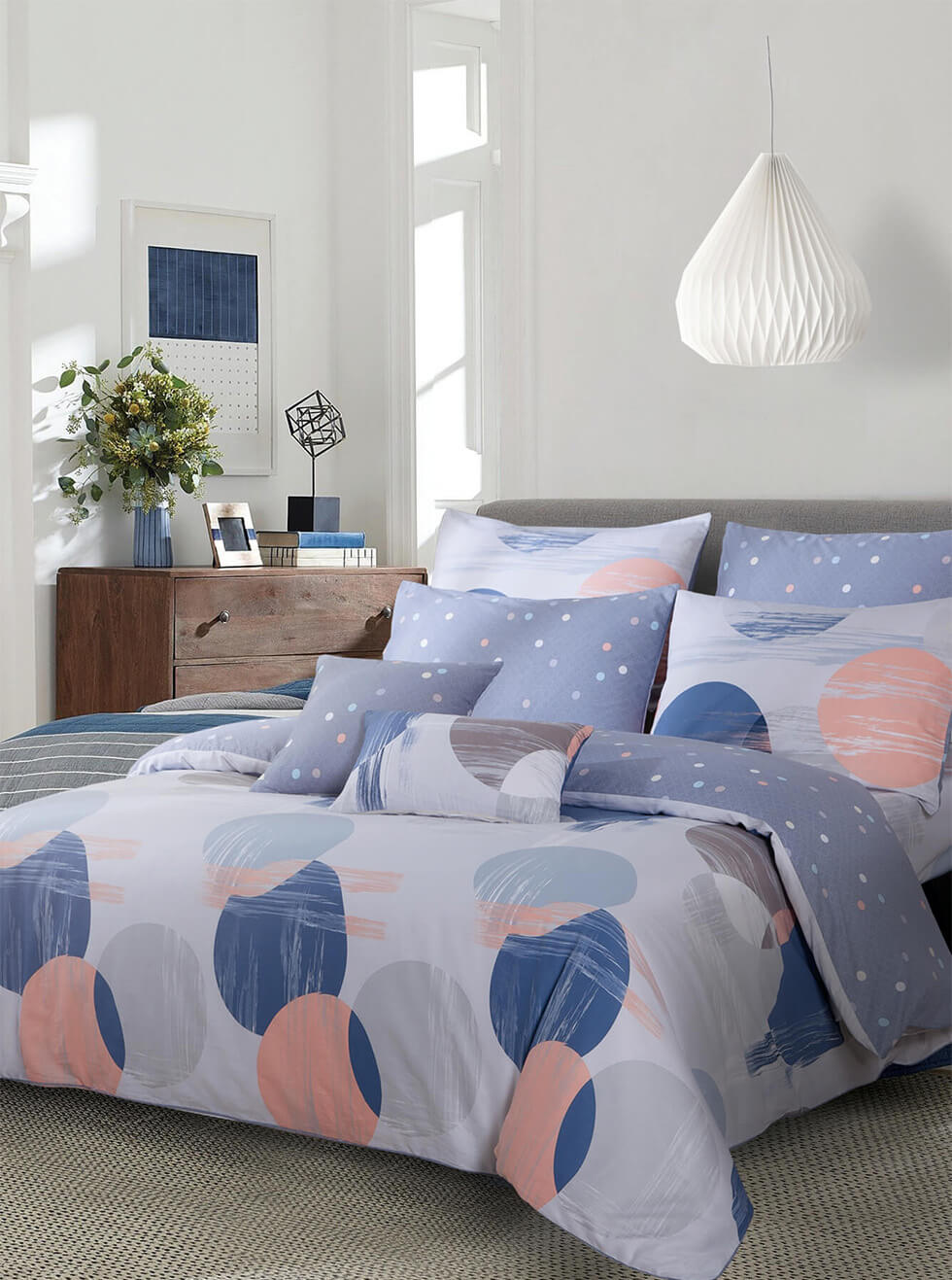 purple bed with a big paper lamp on the ceiling